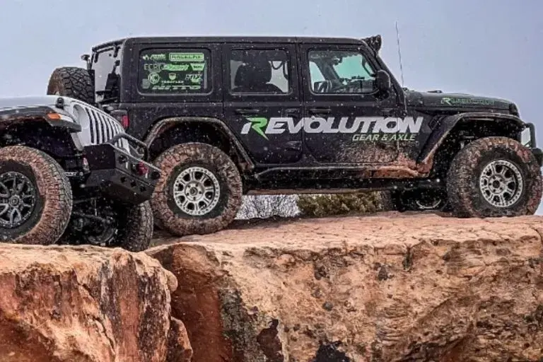 Branded Revolution Gear & Axle Jeep on rocky terrain in harsh conditions.